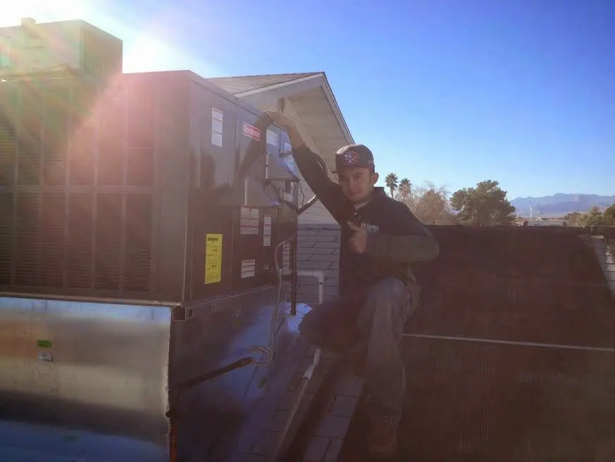 HVAC technician performing HVAC Inspection on a rooftop unit in Sidney